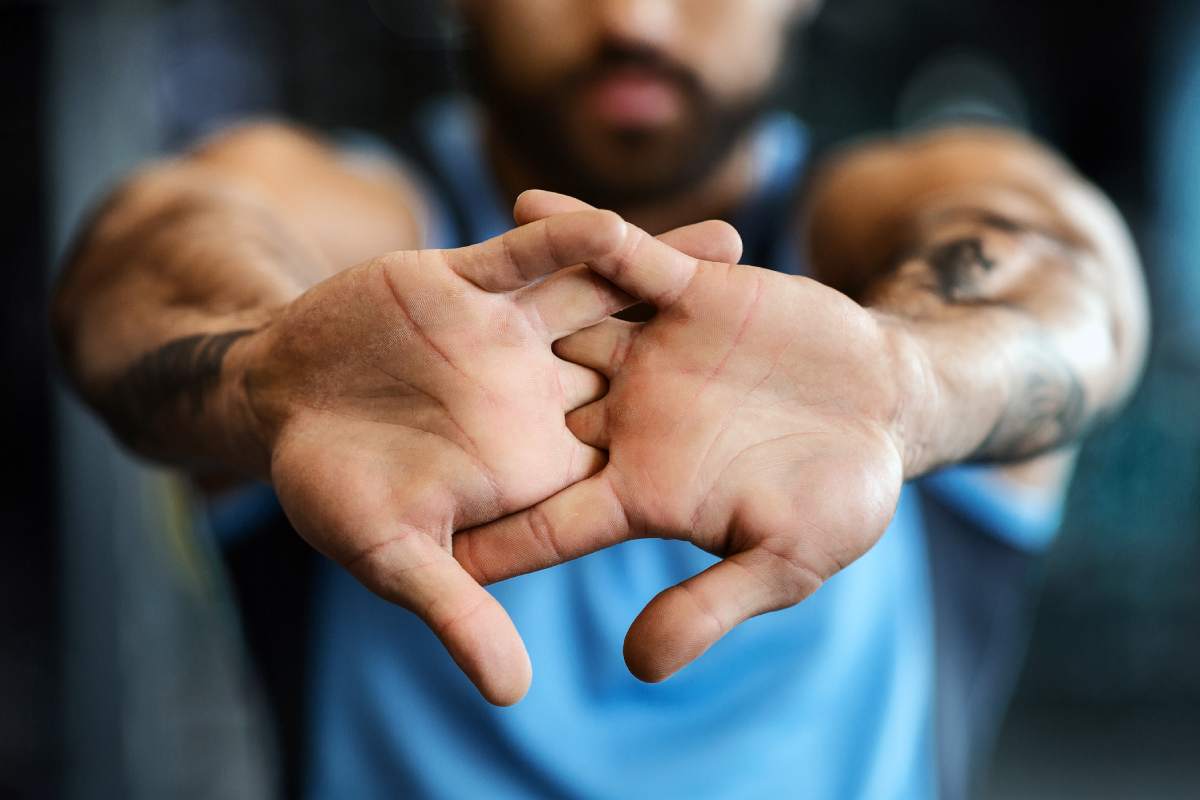 Man warming up his hands before workout training at gym, closeup