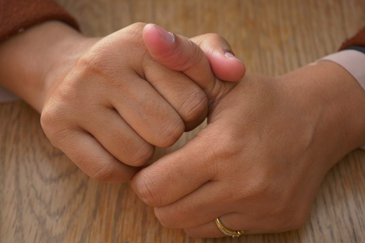 Young women hands suffering pain in thumb finger .